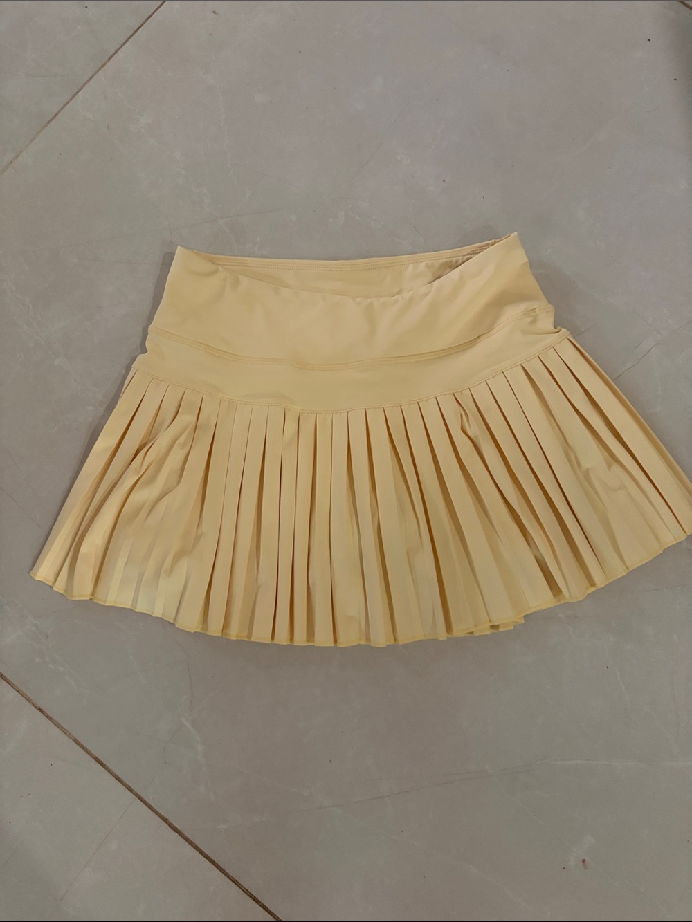 Pleated Mini Skirt in Soft Yellow with shorts under neath